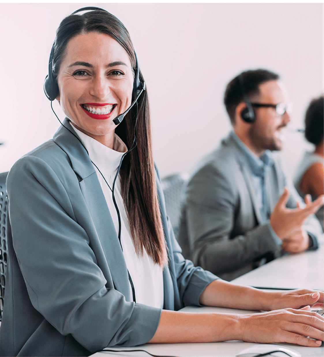 Shot of call center operators working in the office. Female call center agent working with her colleagues in modern office. Smiling beautiful businesswoman working in call center.